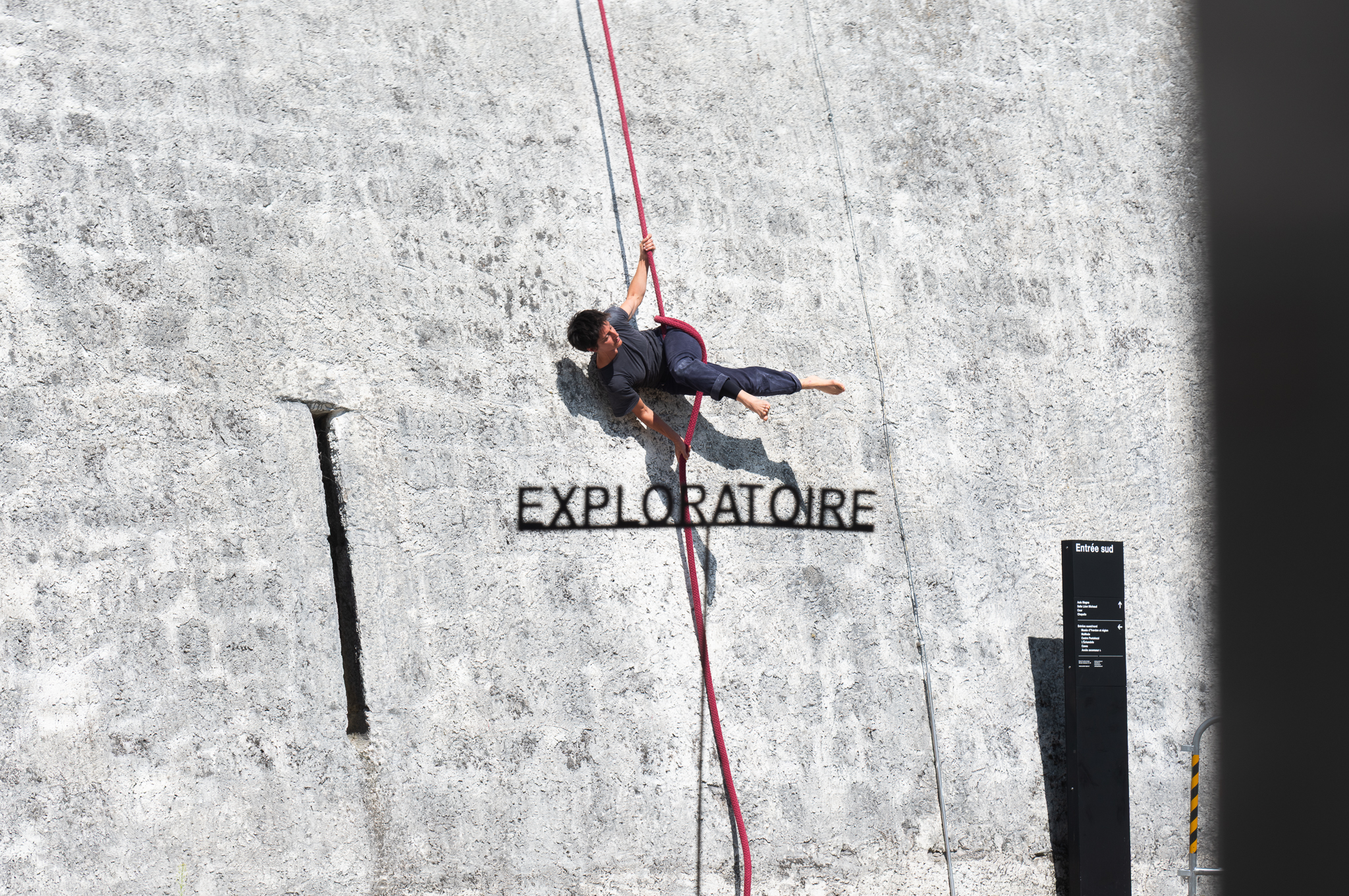 une artiste de la Cie Pieds Perchés fait des acrobaties, avec une corde, contre une façade du Château d'Yverdon-les-Bains 