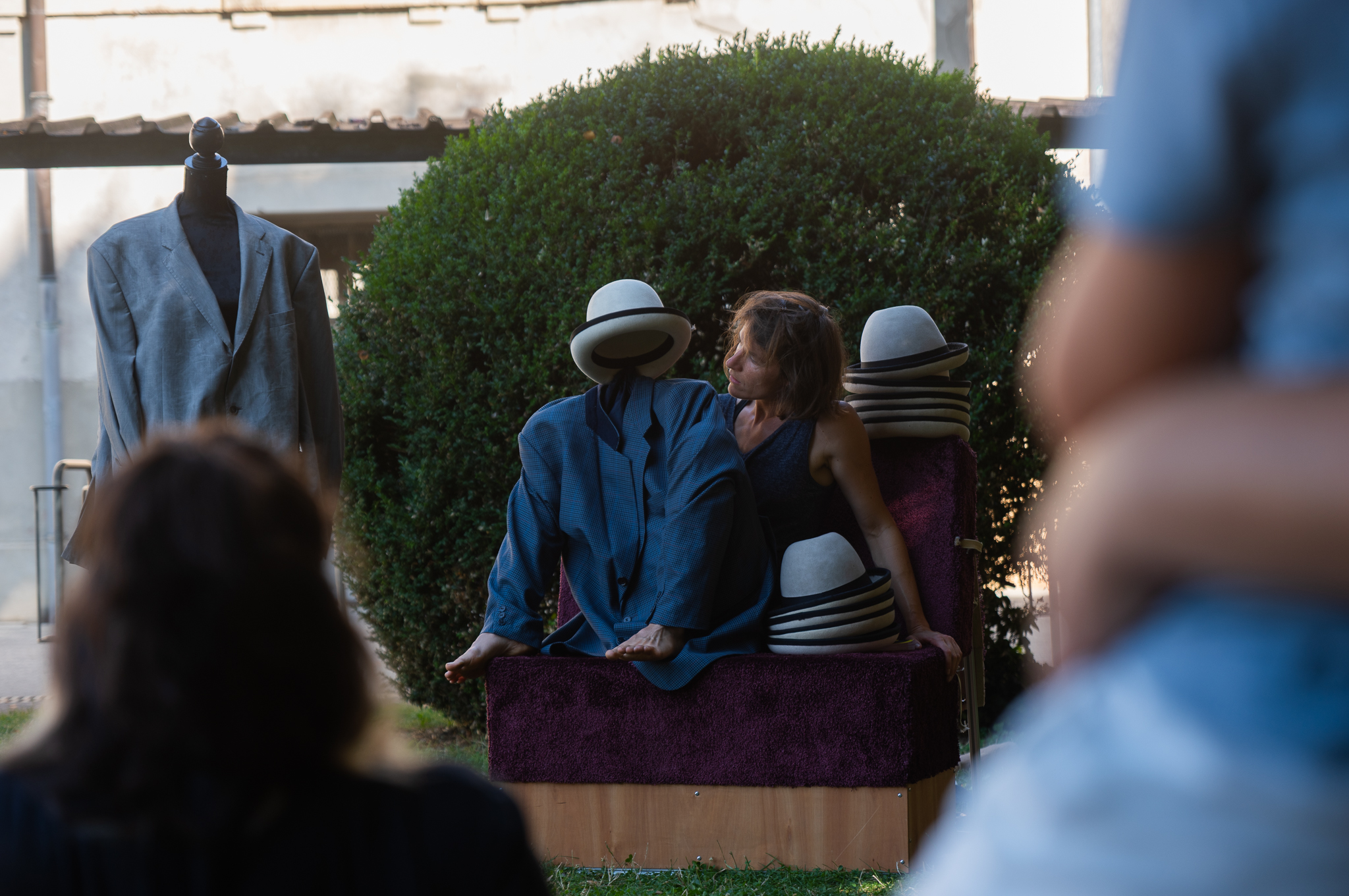Une artiste joue et jongle avec des chapeaux dans un parc 